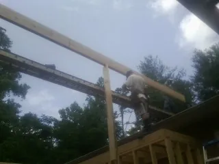 Carpenter setting a ridge beam over a new addition frame — Ice Dam Removal by Roofing Brothers in Macedonia