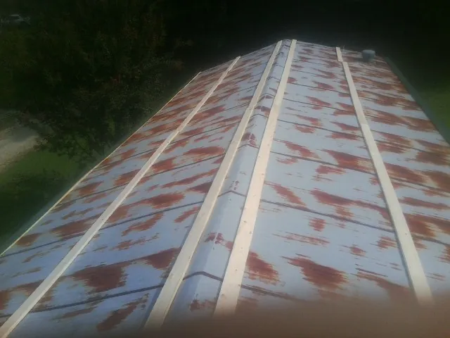 Rusted metal roof panels with new wood purlins before replacement — Storm Damage Roof Repair in Macedonia by Roofing Brothers