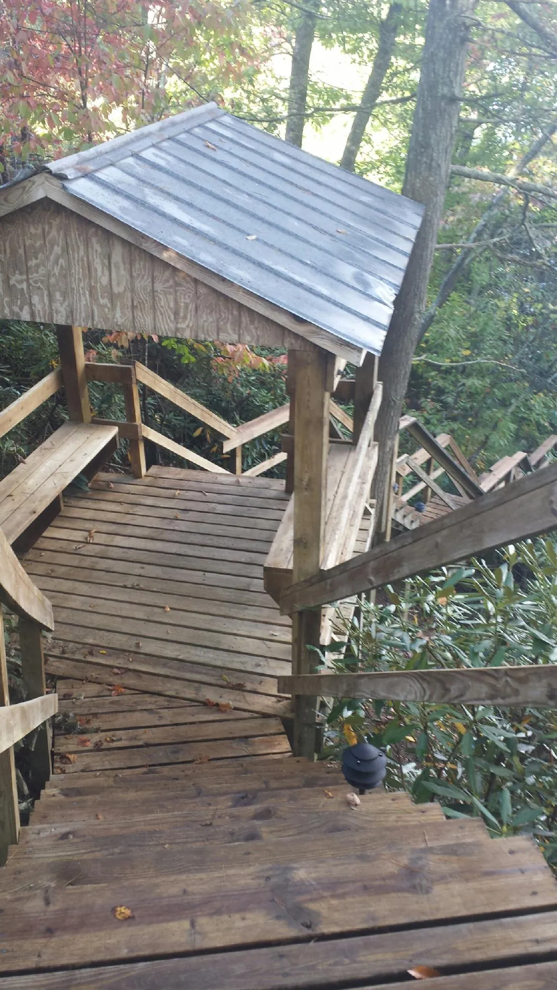 Metal roofed shelter over wooden steps on a wooded walkway — Skylight Repair & Installation work by our crew in Macedonia