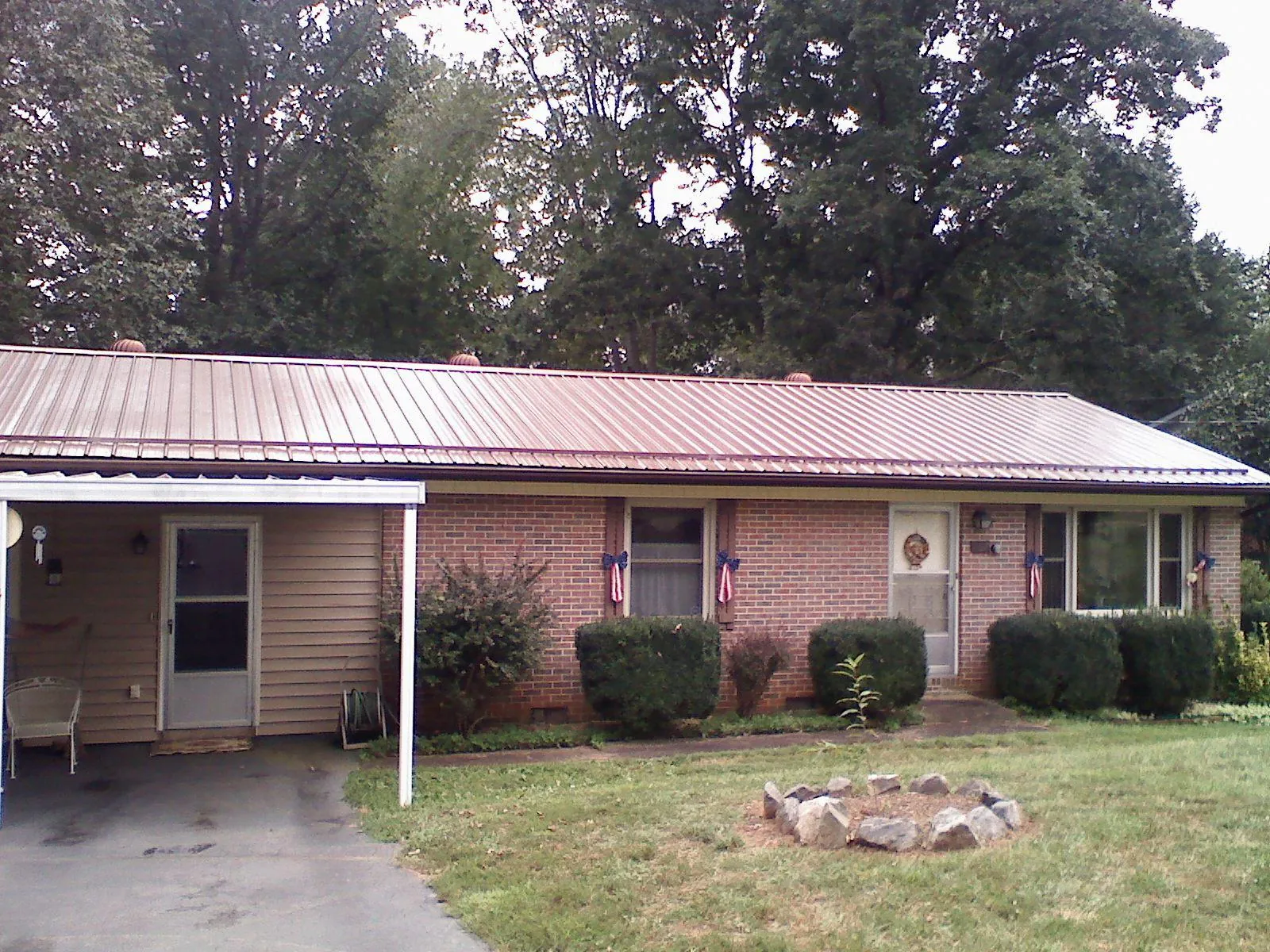 Bronze metal roof and carport on a brick ranch home — Roof Repair work by our crew in Macedonia